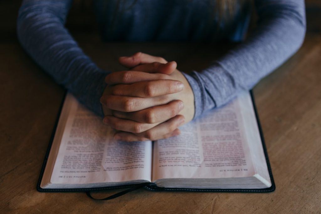 man-holding-his-hands-on-open-book-b-shpu5m3nk